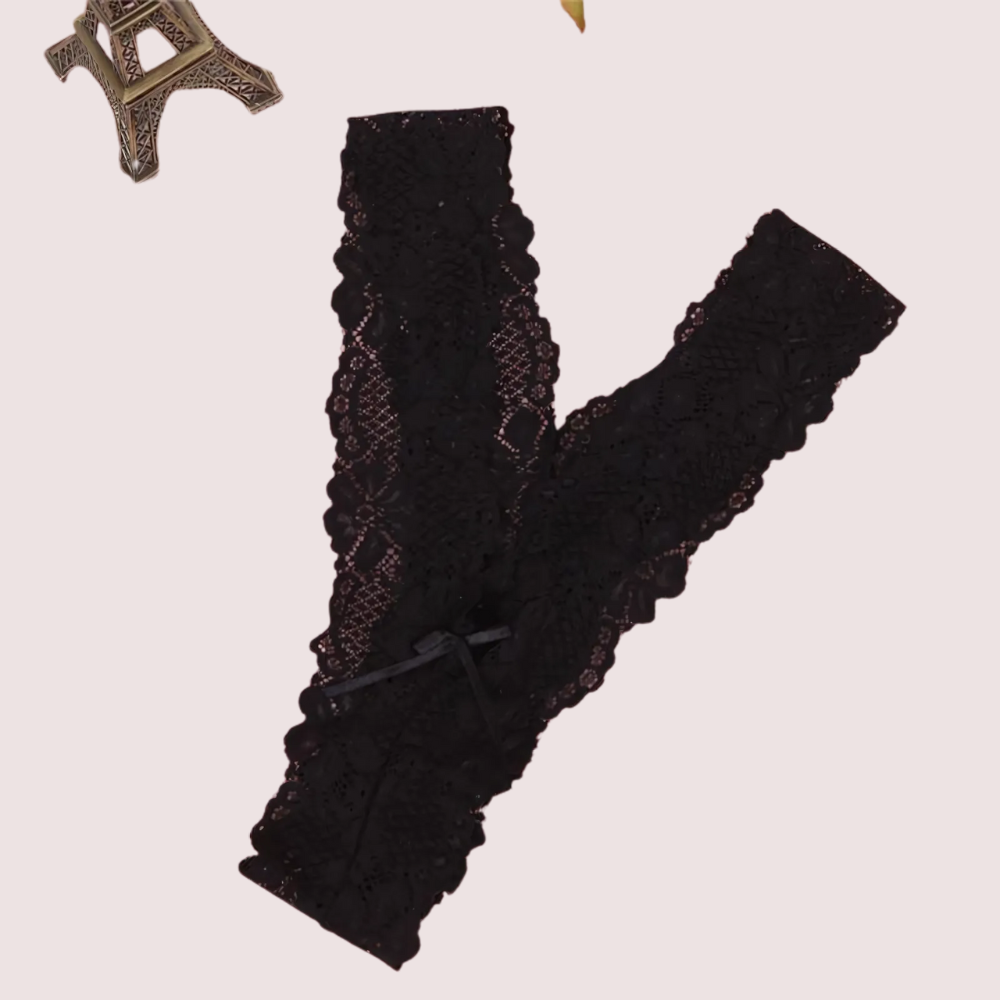 Black lace gloves with a decorative bow on a light pink background