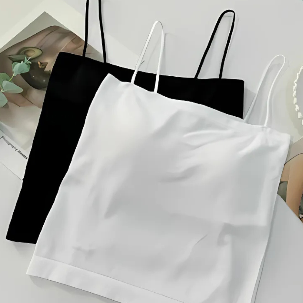 Black and white spaghetti strap tops on a light gray surface.