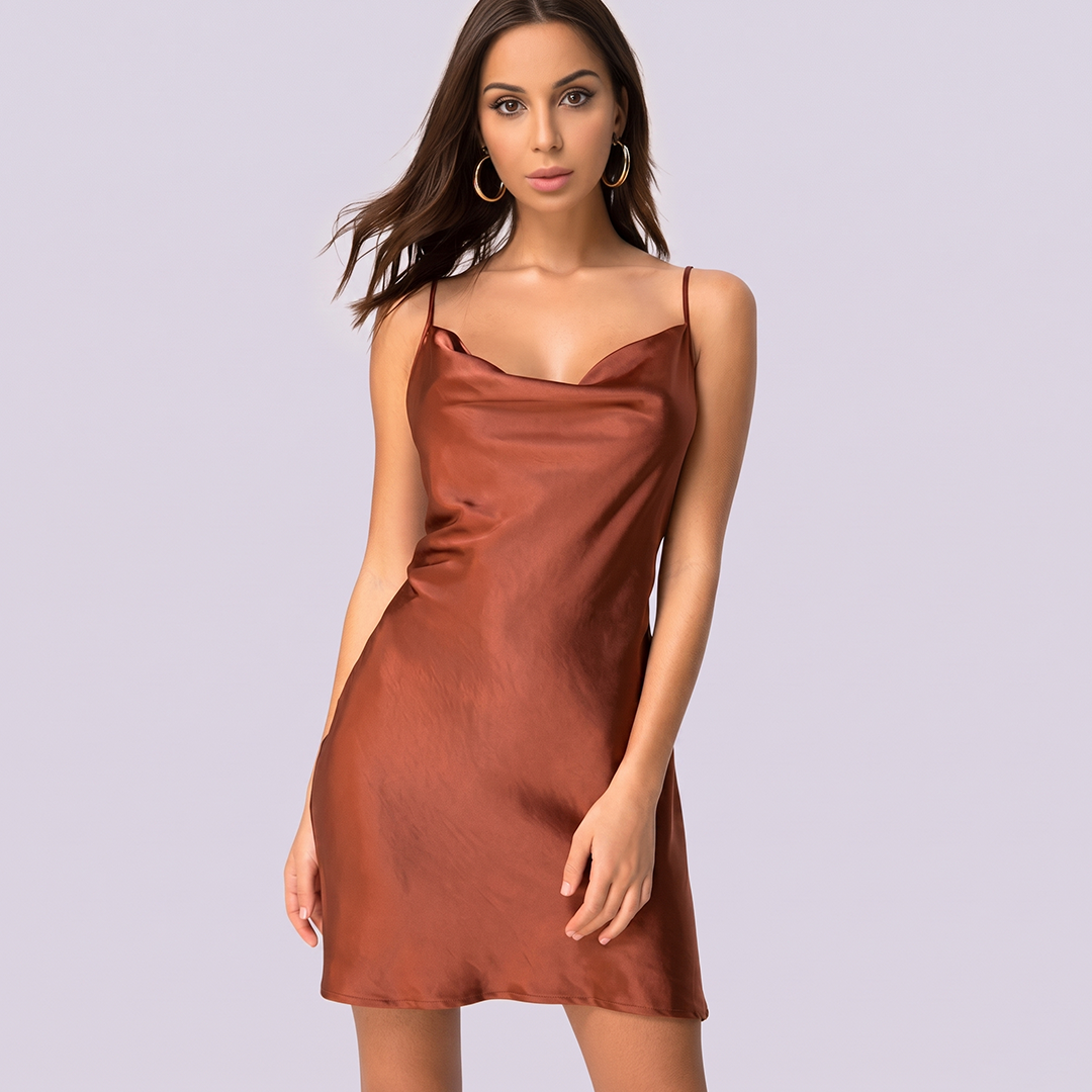 Woman wearing a brown satin slip dress against a light gray background