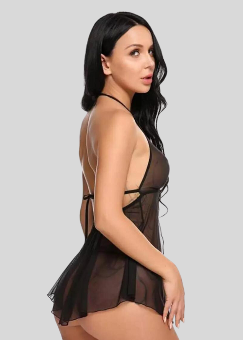 Woman wearing a sheer black lingerie set on a light gray background
