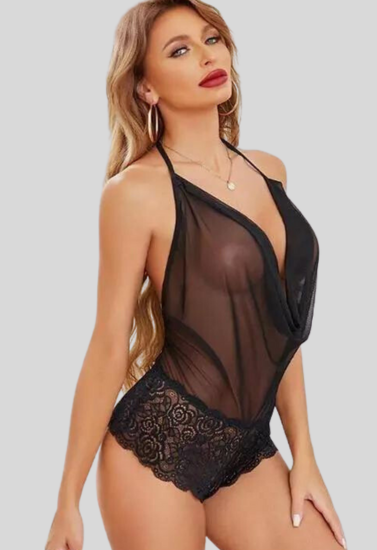 Woman wearing a black lace lingerie set against a plain background