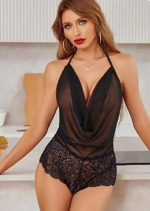 Woman wearing a black lace lingerie set in a well-lit room.