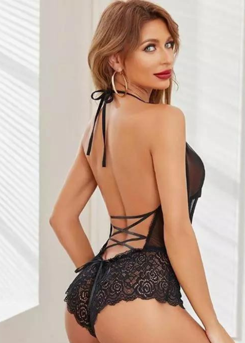 Woman wearing a black lace lingerie set with a white background
