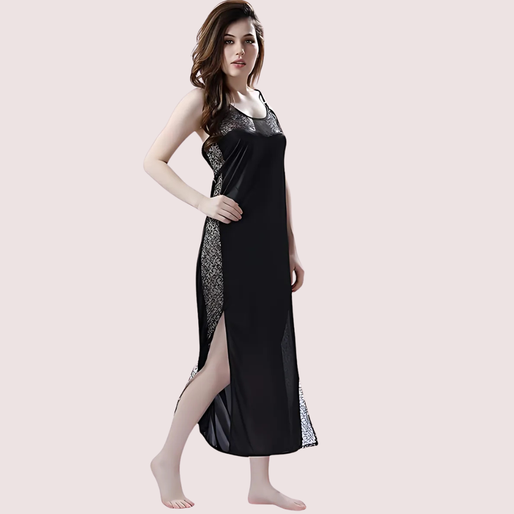 Woman wearing a black nightgown with lace details on a light pink background