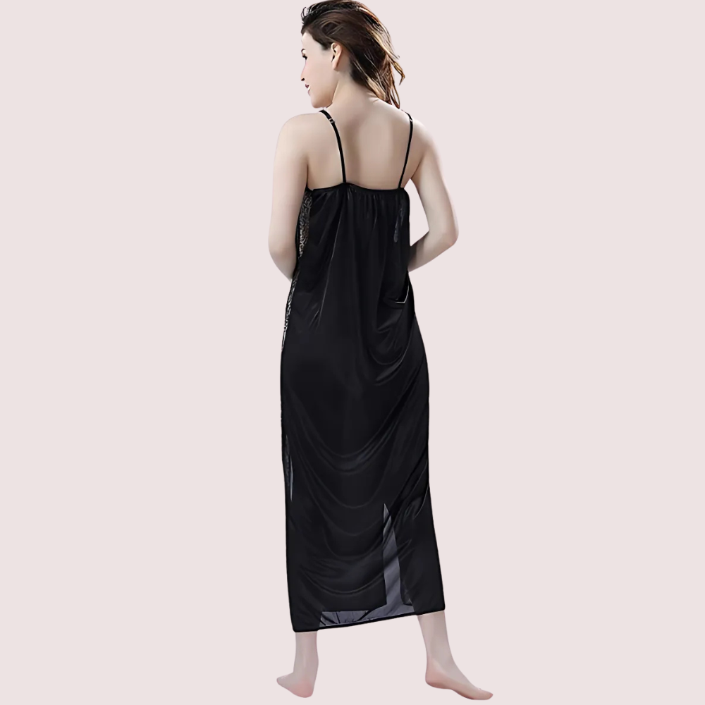 Woman wearing a black satin nightgown on a light pink background