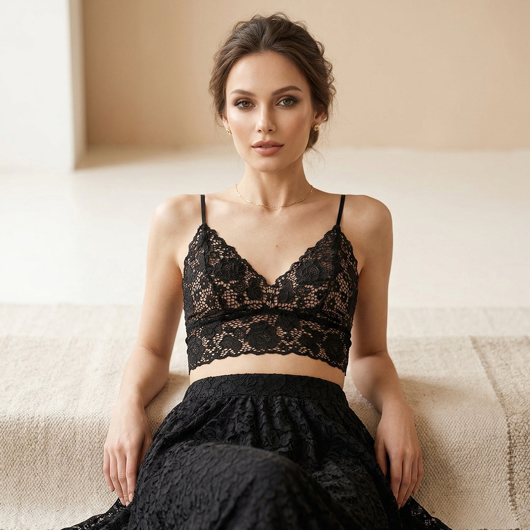 Woman wearing a black lace outfit sitting on a couch.