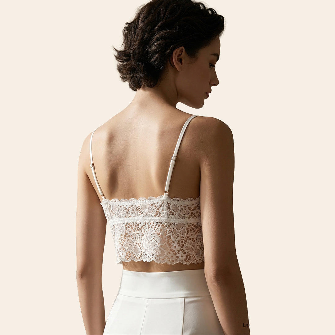 Woman wearing a white lace top against a beige background
