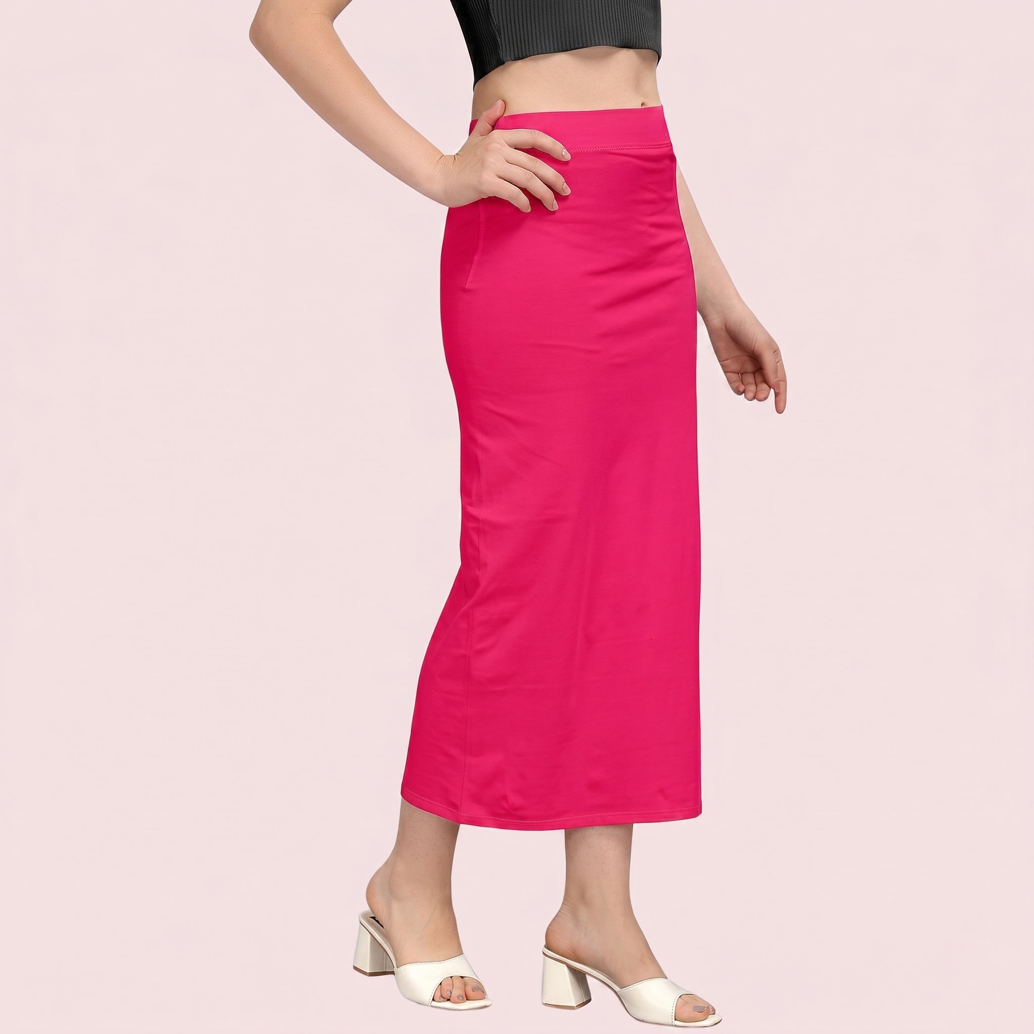 Person wearing a bright pink skirt on a light pink background