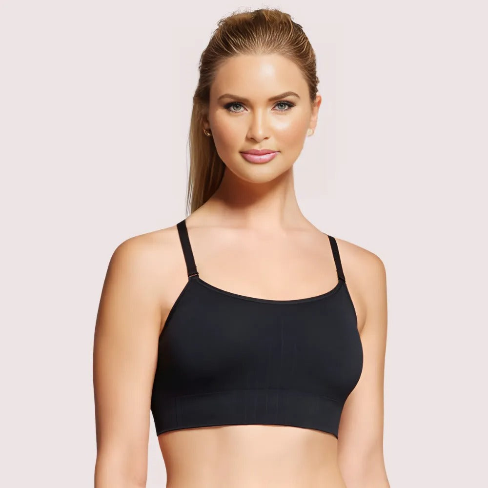Woman wearing a black sports bra against a light pink background
