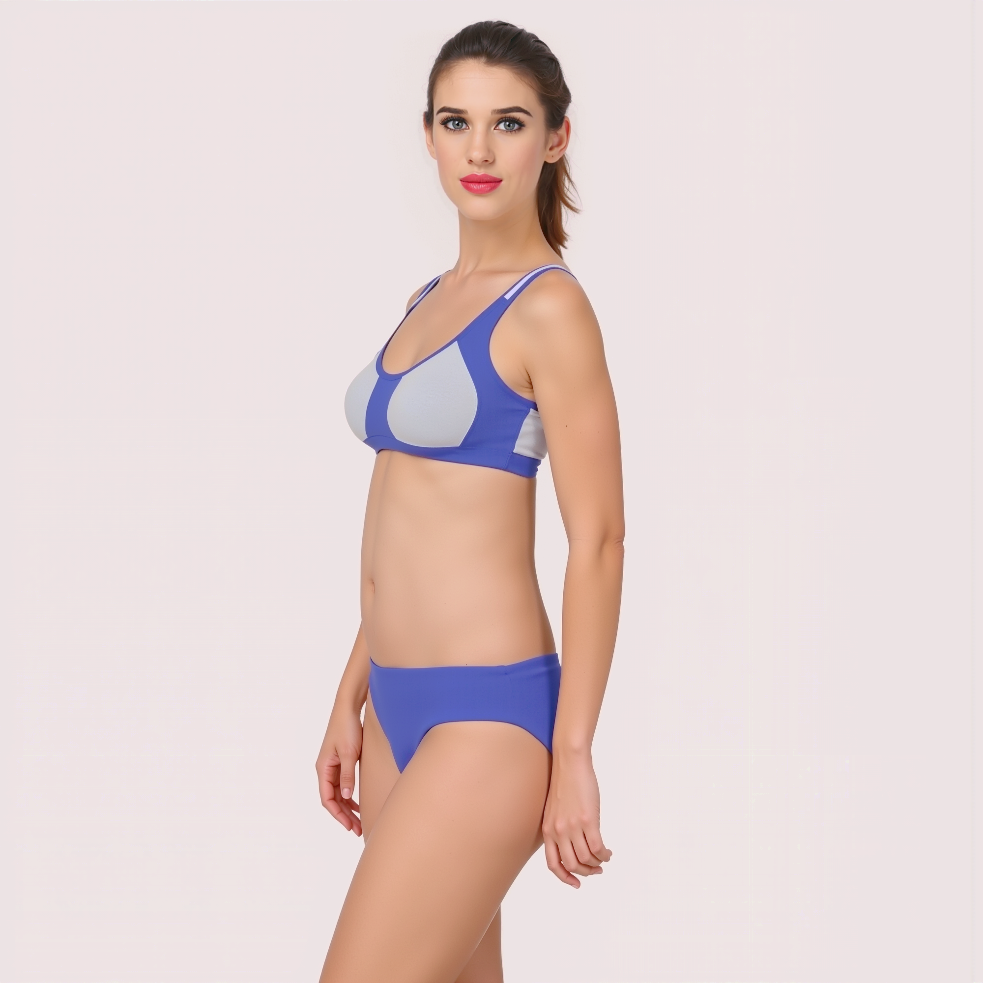 Woman wearing a blue bikini on a light pink background