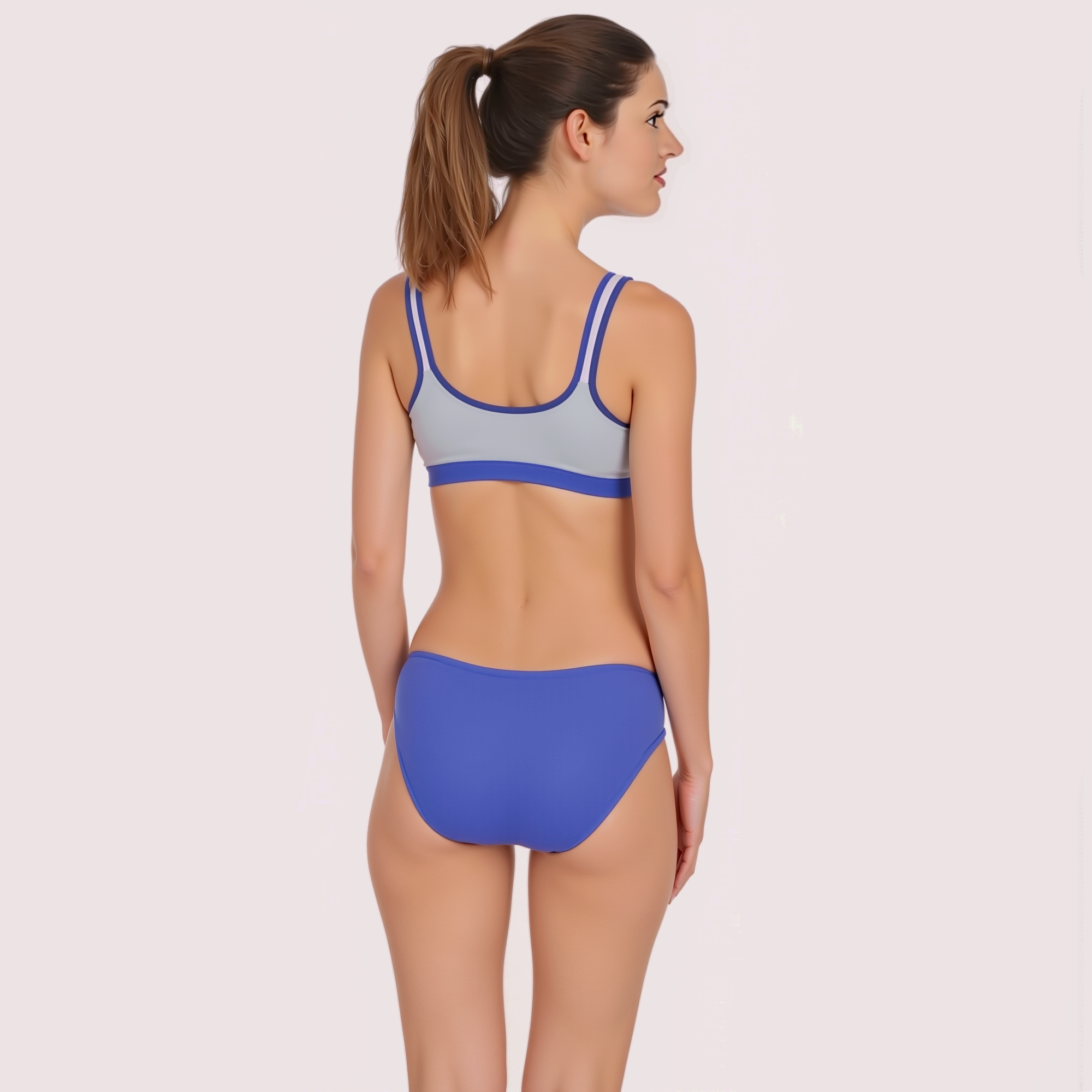Woman wearing a blue and gray bikini on a light pink background