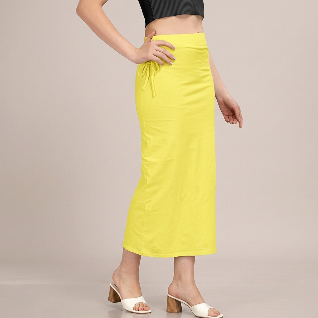 Person wearing a bright yellow skirt on a beige background