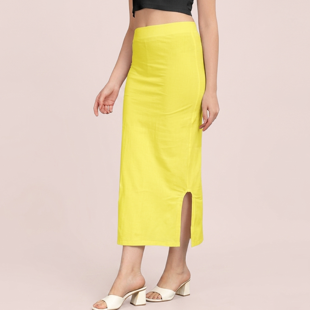 Person wearing a bright yellow skirt with a slit on a light pink background