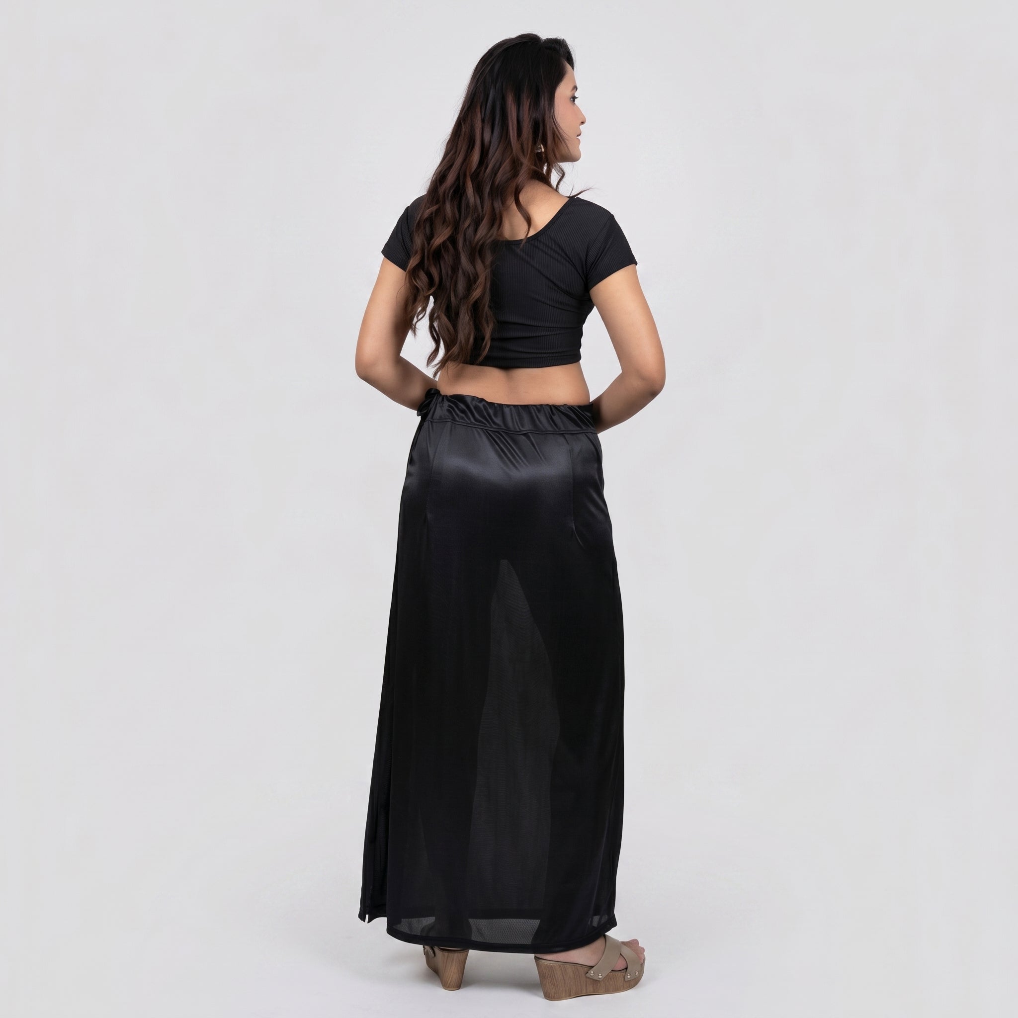 Woman wearing a black outfit with a long skirt on a white background