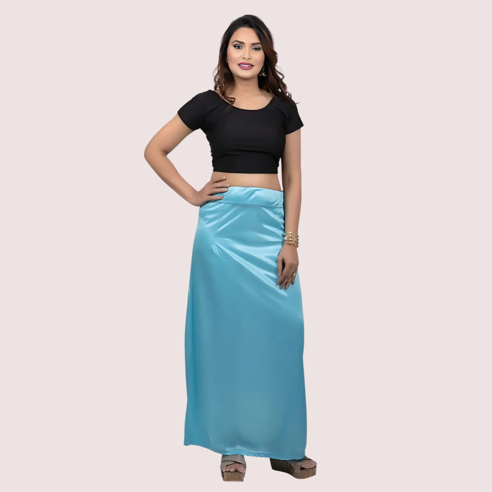 Woman wearing a black top and blue skirt on a beige background