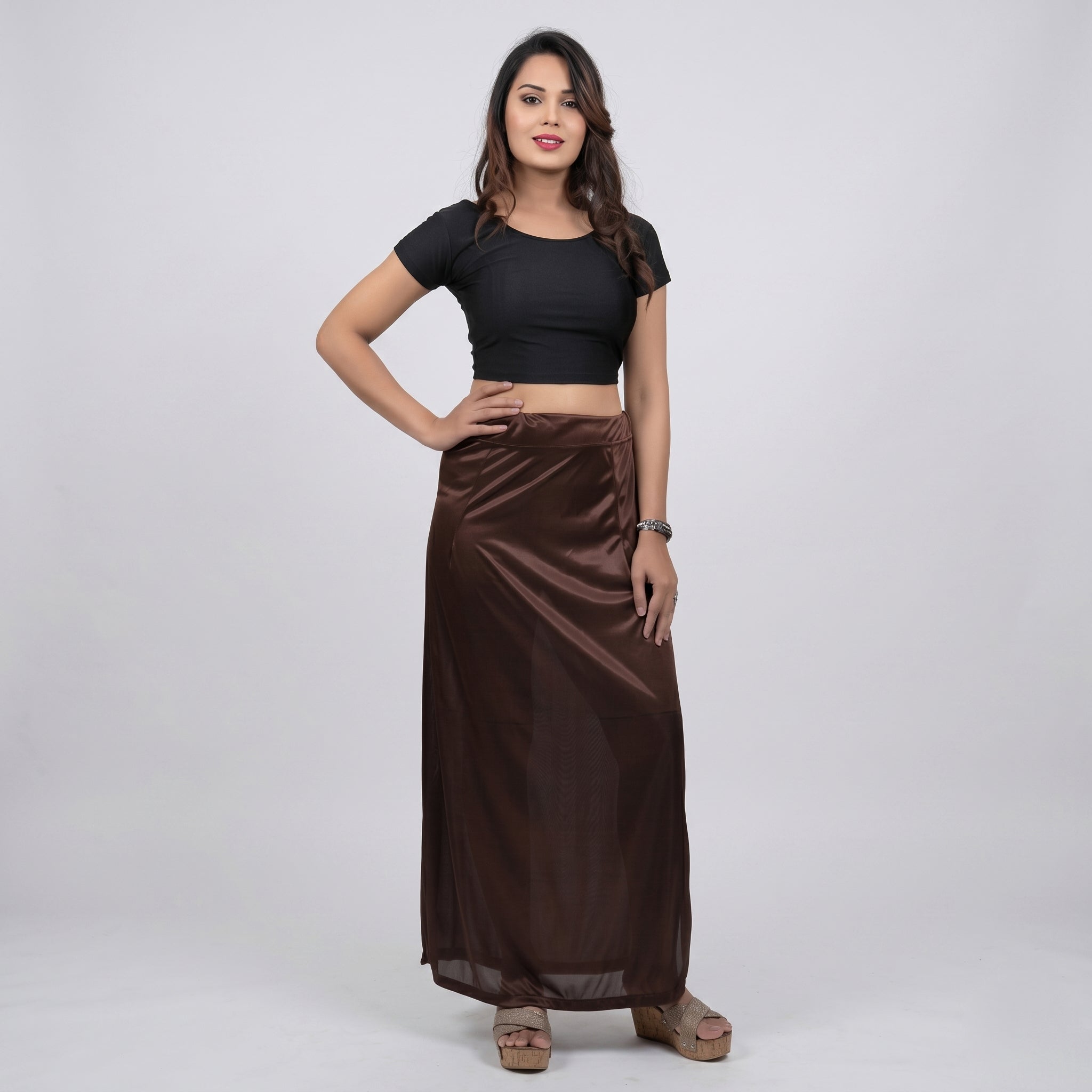Woman wearing a black top and brown skirt on a white background