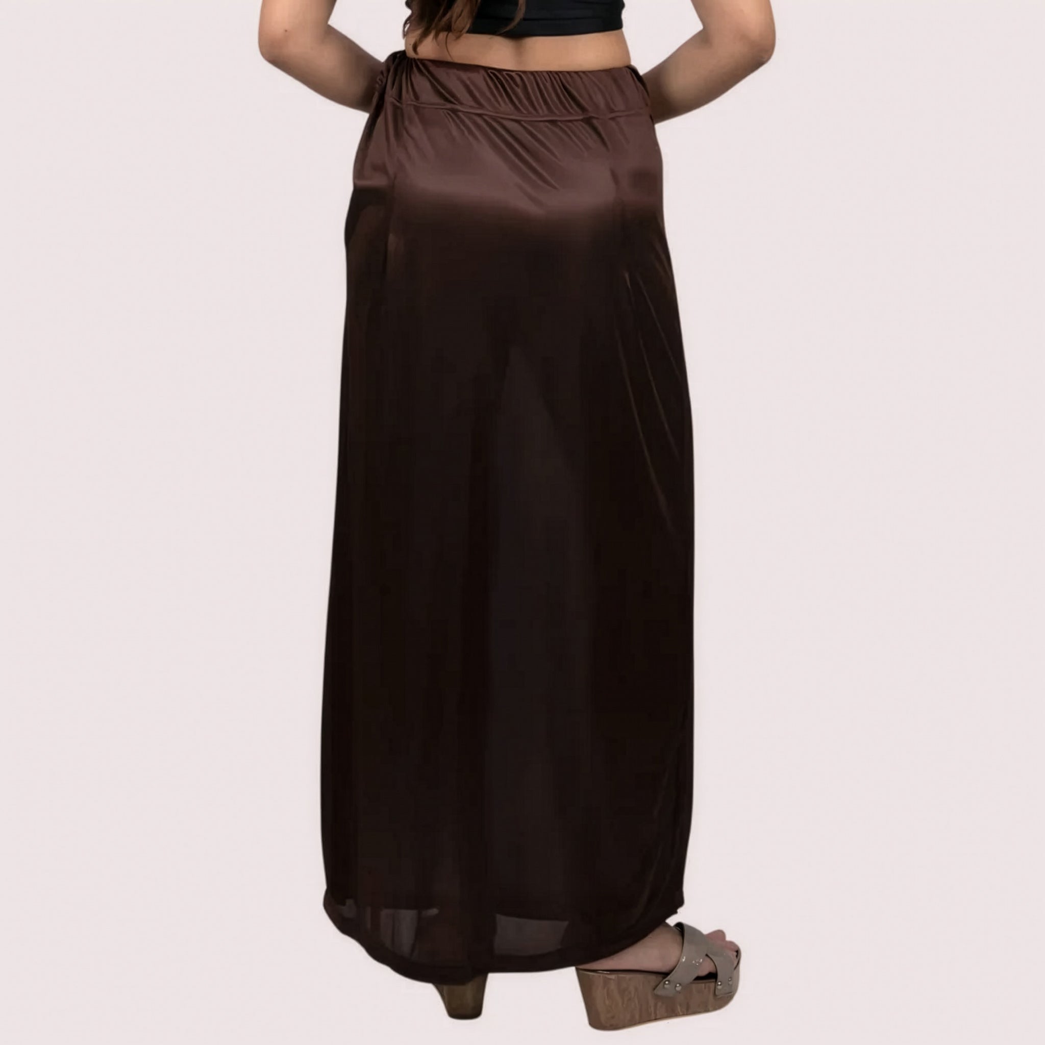 Brown satin skirt worn by a person on a light pink background