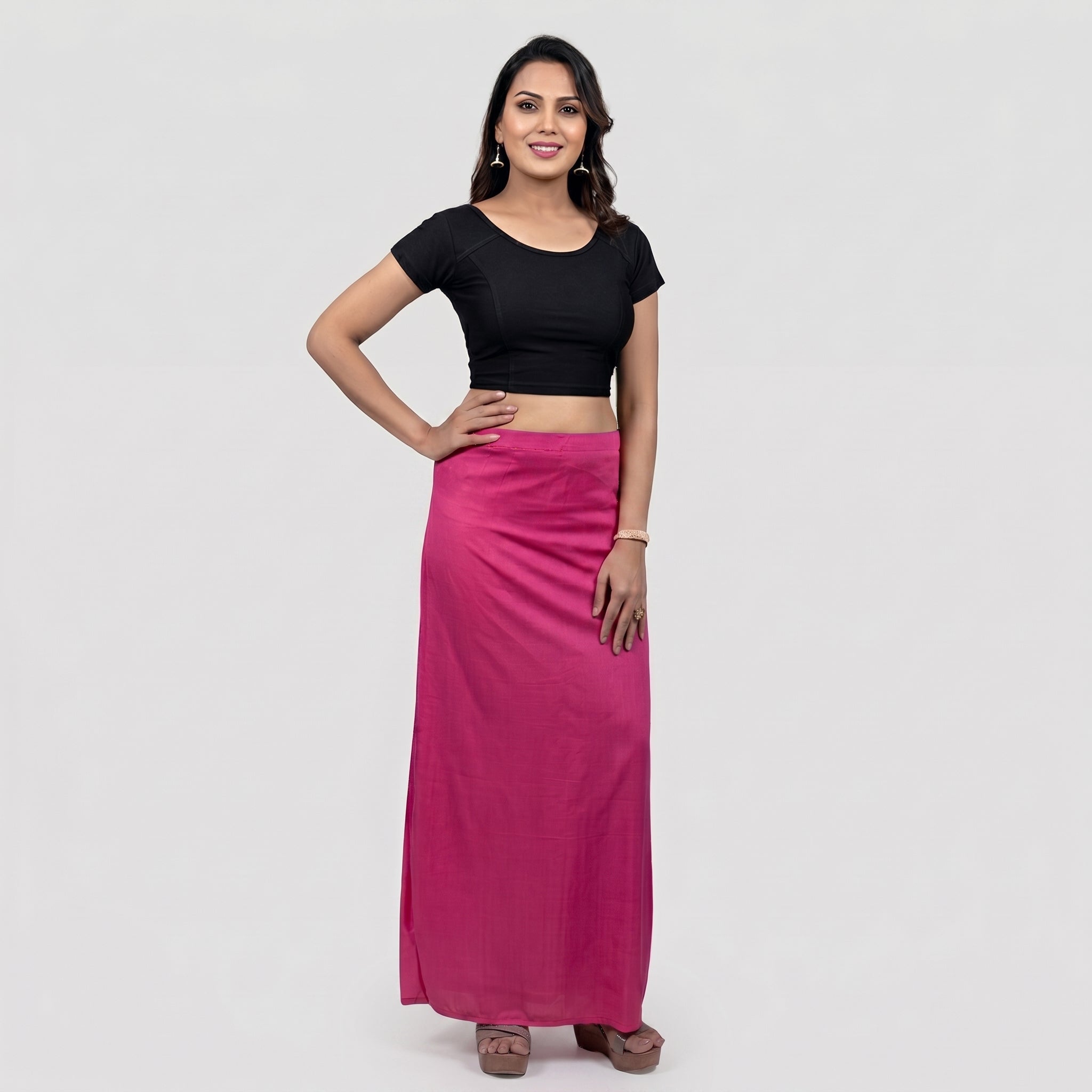 Woman wearing a black top and pink skirt on a white background