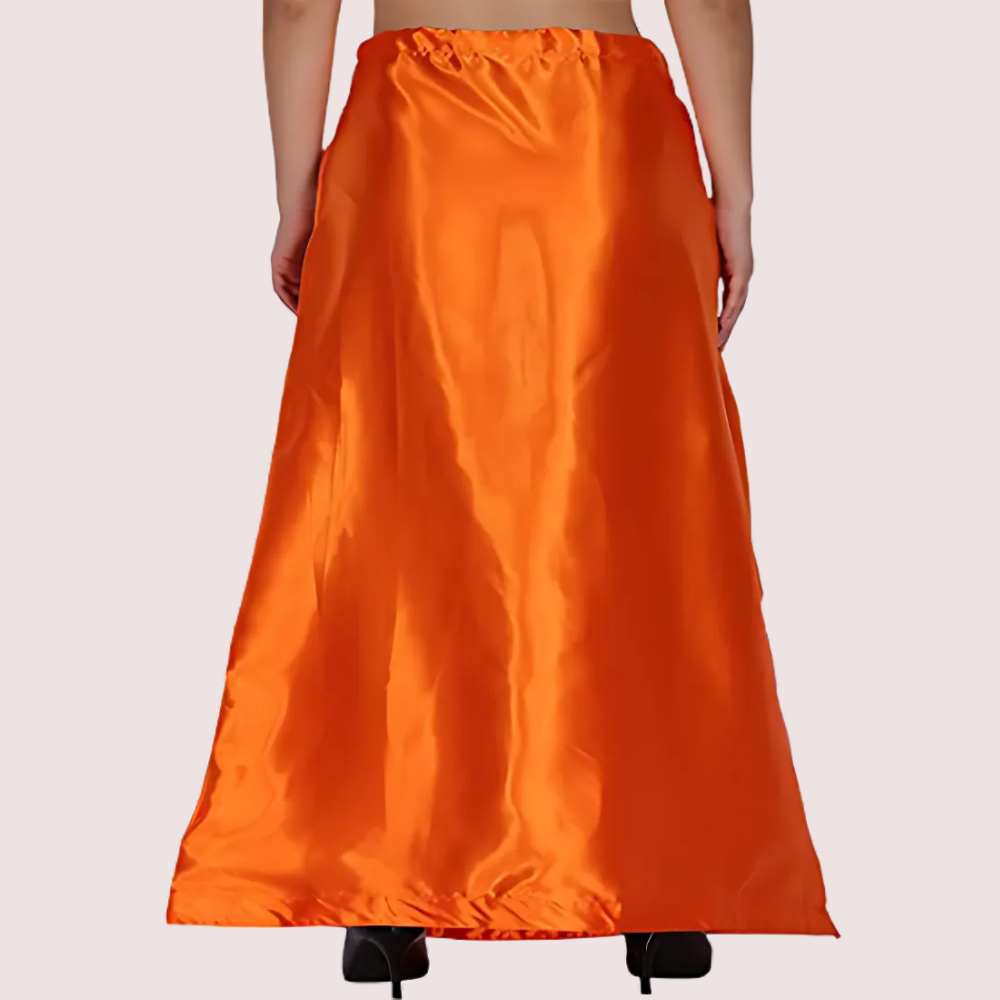 Orange satin skirt worn by a person on a plain background