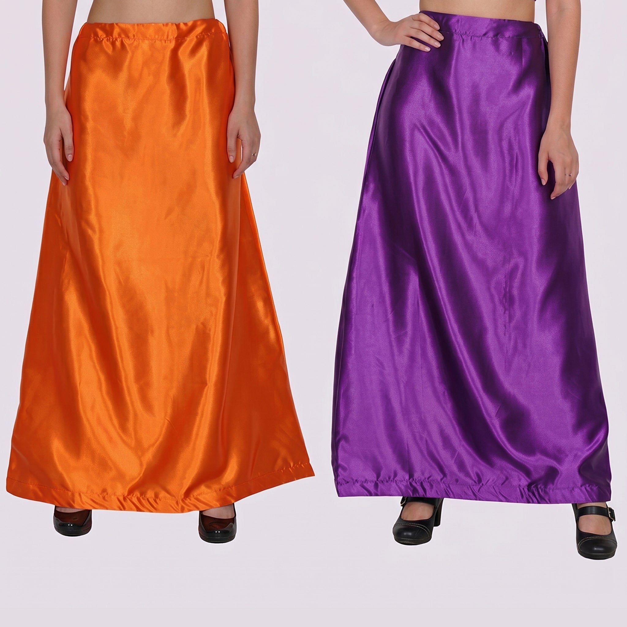 Two long satin skirts, one orange and one purple, on a plain background.
