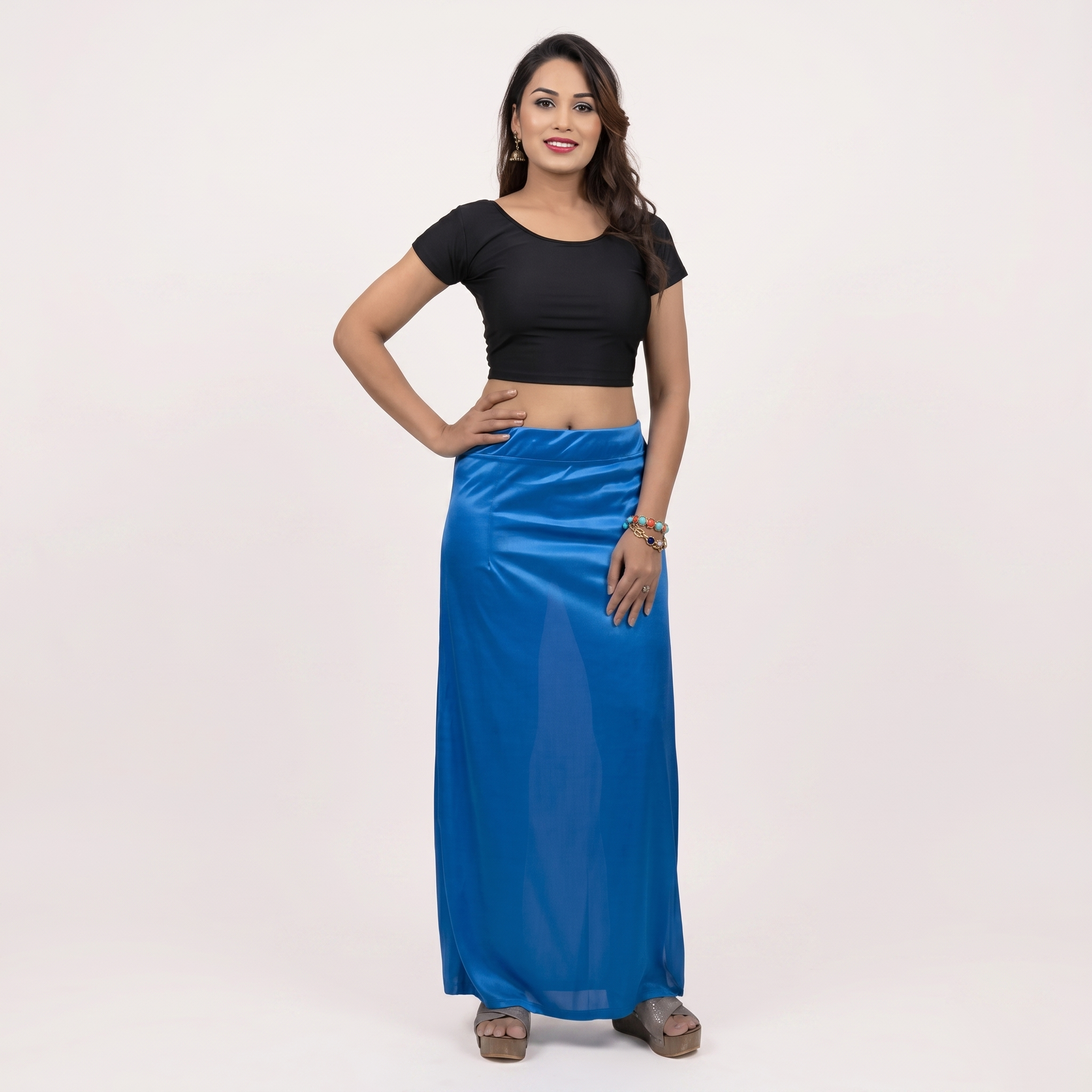 Woman wearing a black top and blue skirt on a white background
