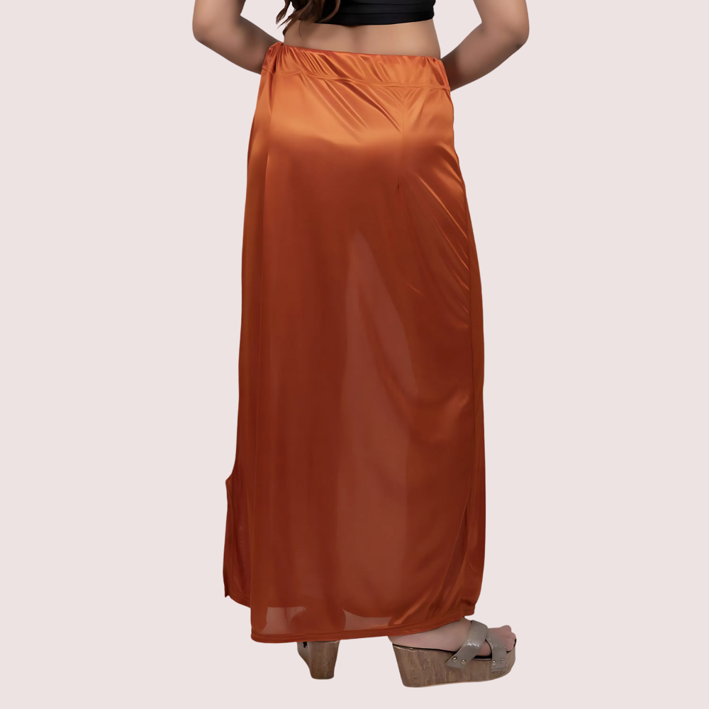 Orange satin skirt worn by a person on a light pink background