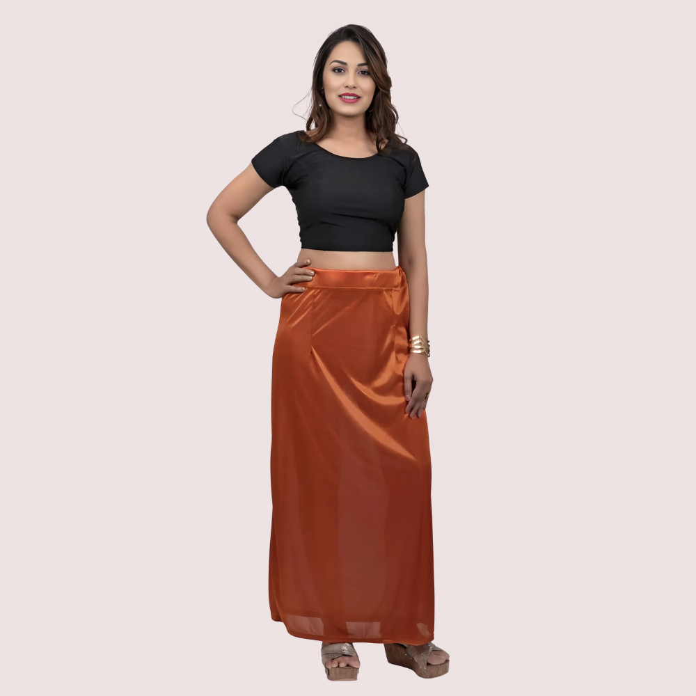 Woman wearing a black top and orange skirt on a beige background
