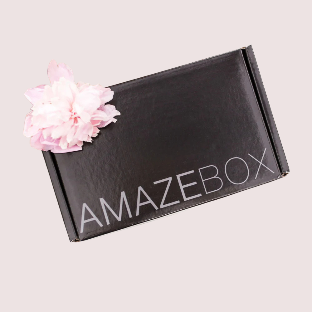 Black 'Amazebox' box with a pink flower on a light gray background