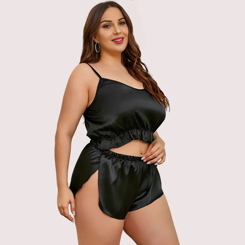 Woman wearing a black satin top and shorts set on a plain background