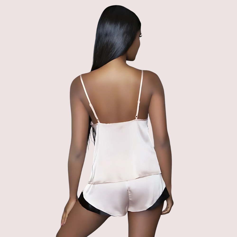 Woman wearing a white satin nightgown with thin straps on a beige background
