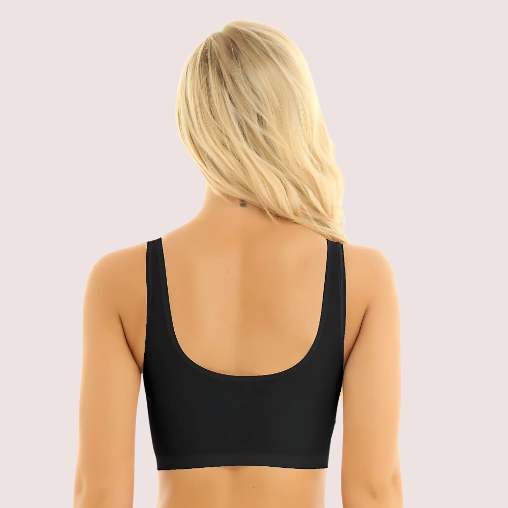 Person wearing a black sports bra on a light gray background