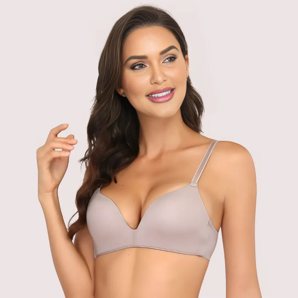Woman wearing a beige bra against a light pink background