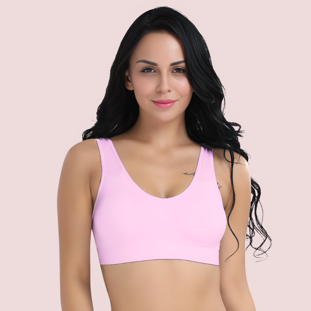 Woman wearing a pink sports bra against a light pink background