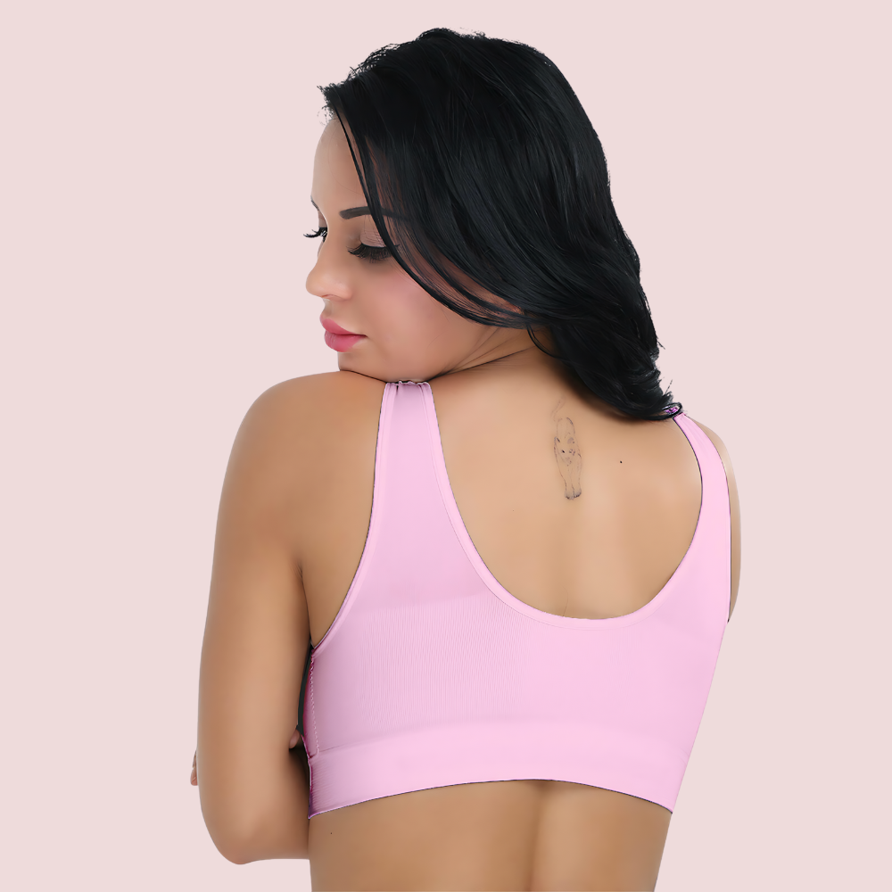 Woman wearing a pink sports bra against a light pink background