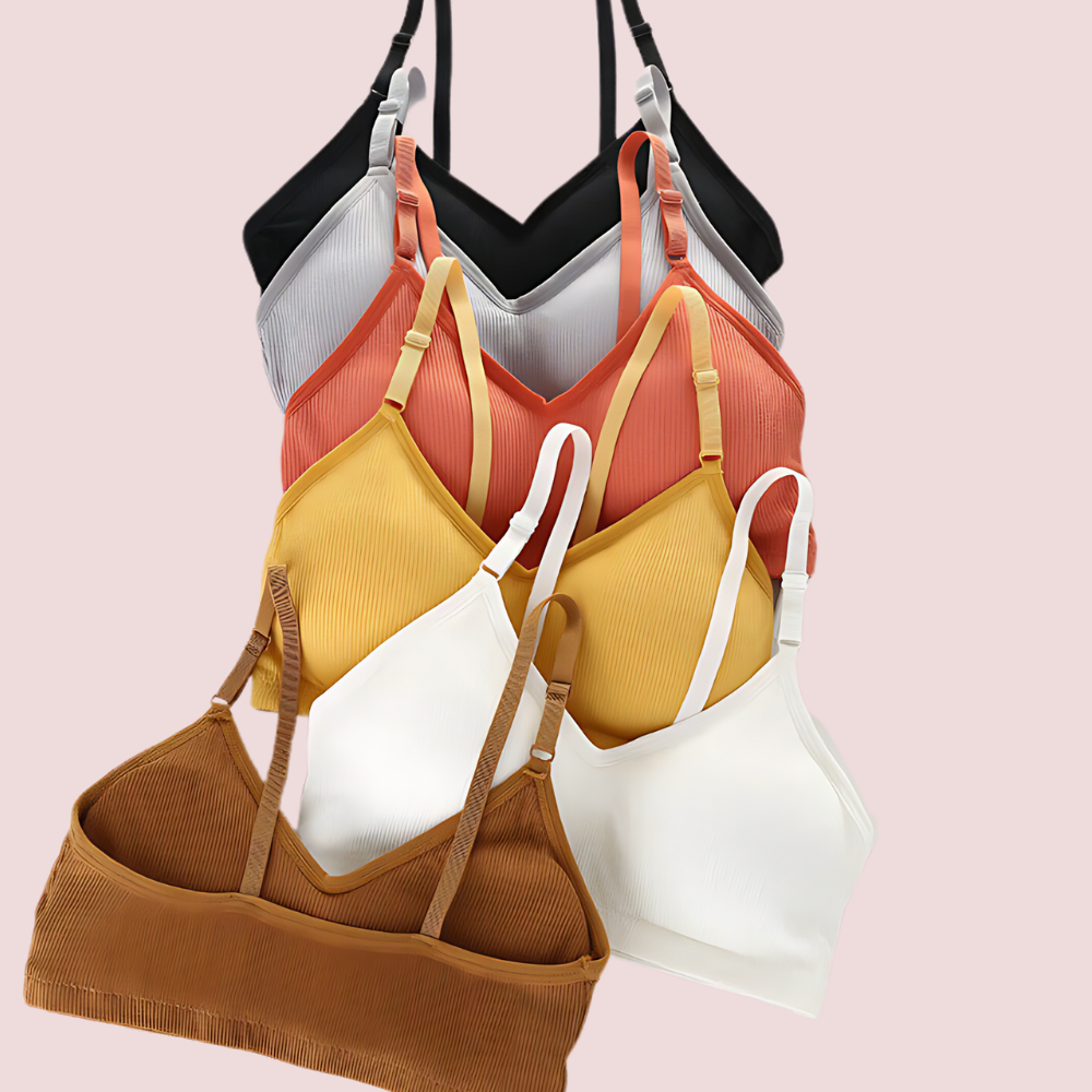 Set of colorful bras on a light pink background