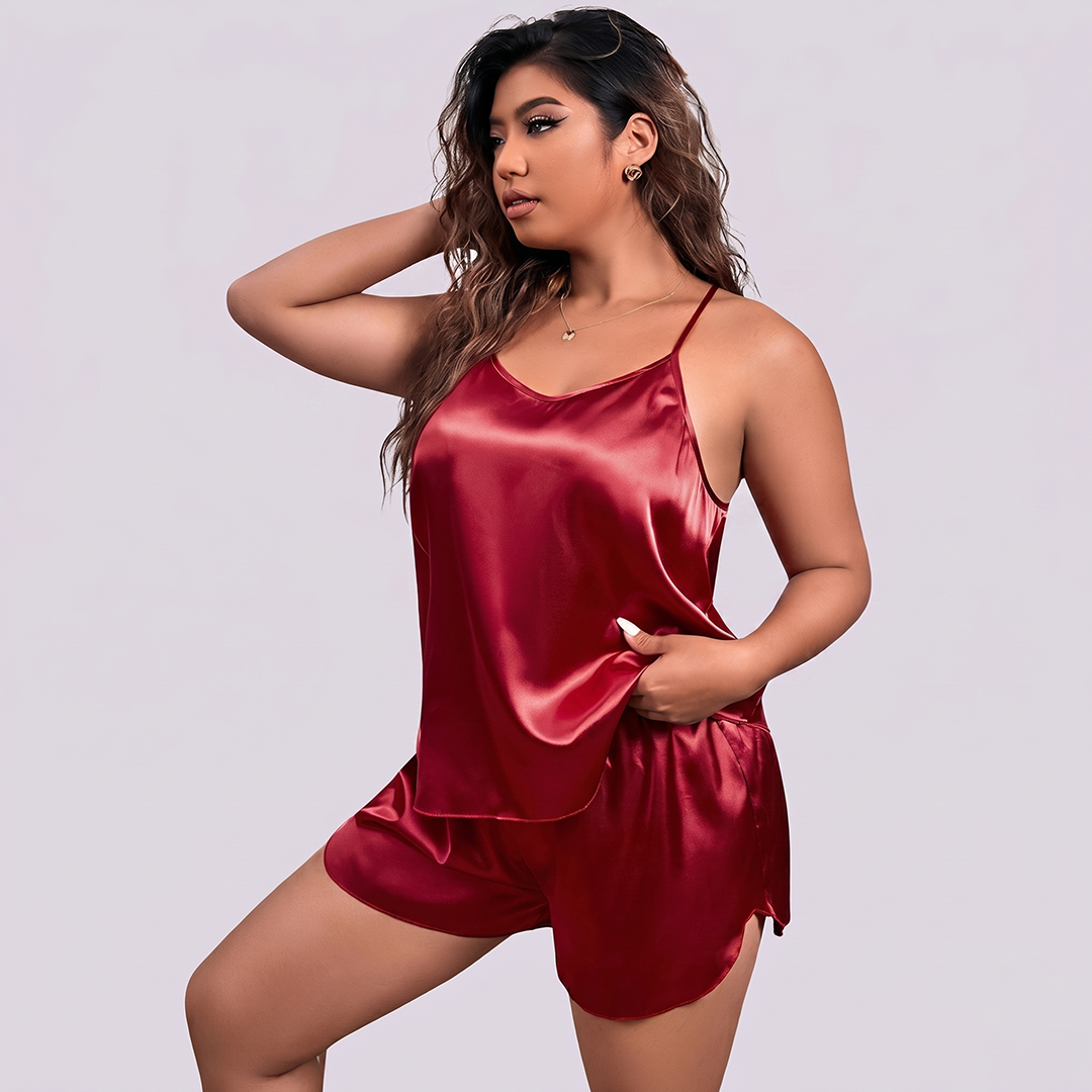Woman wearing a red satin pajama set against a plain background