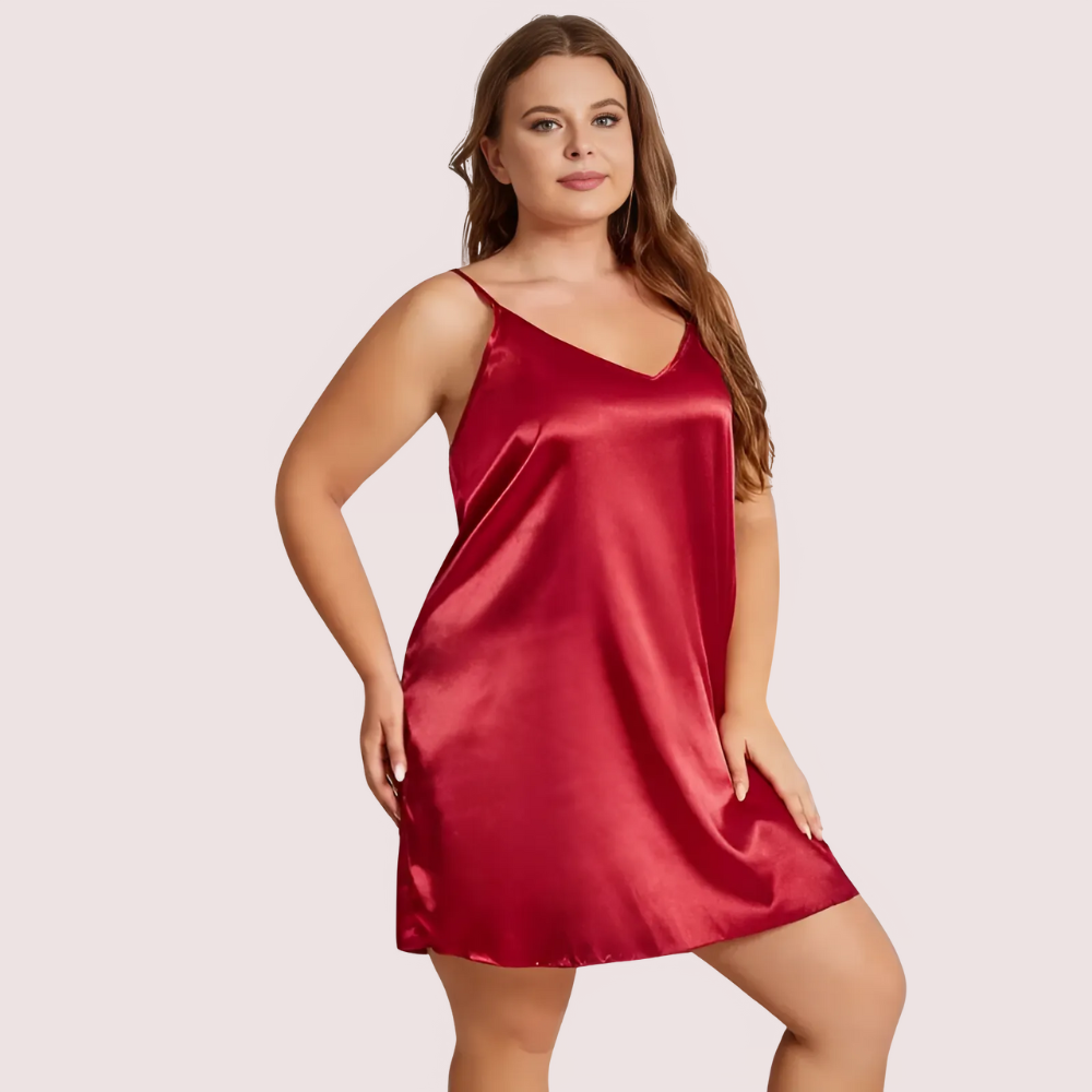 Woman wearing a red satin nightgown against a plain background