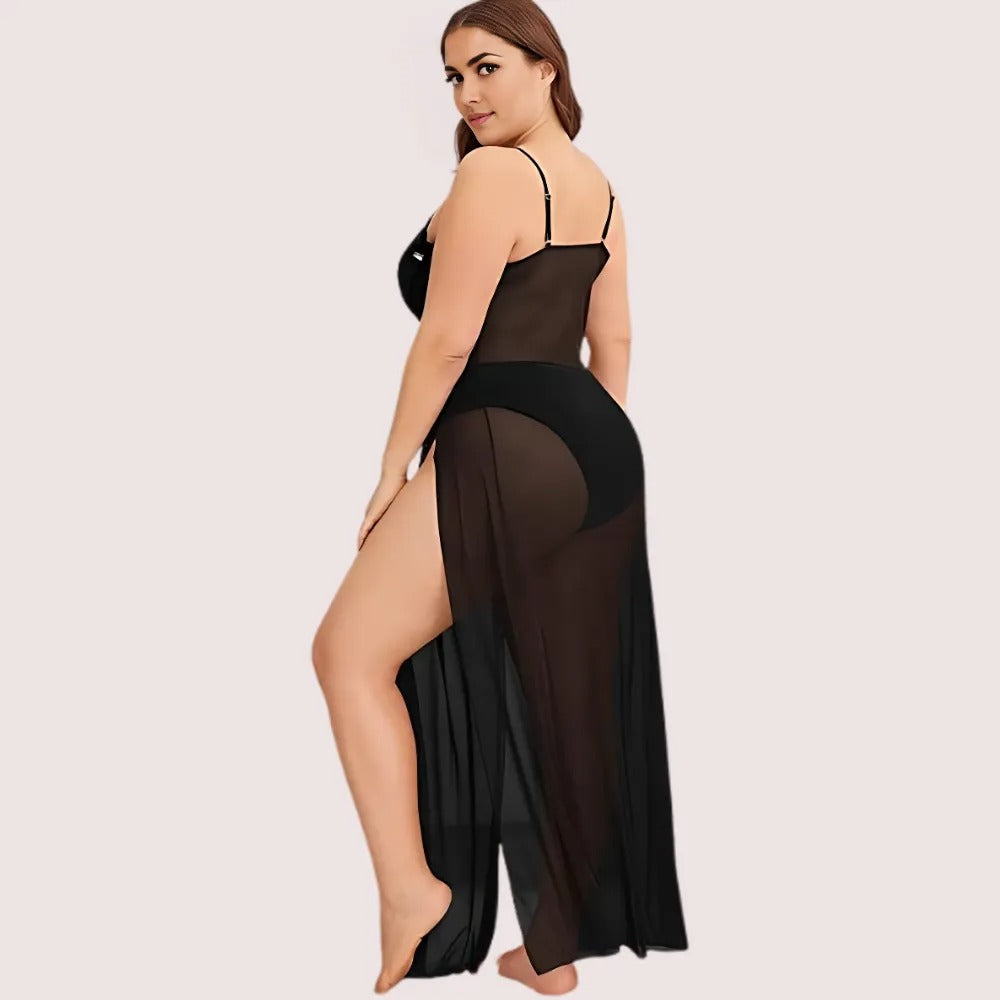 Woman wearing a black sheer dress with a high slit on a light pink background