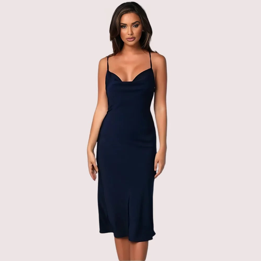 Woman wearing a navy blue slip dress on a light pink background