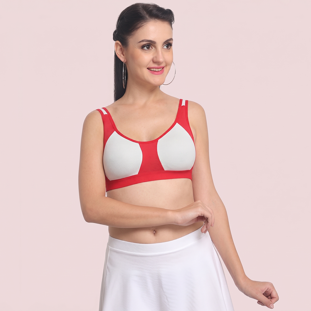 Woman wearing a red and white bra against a light pink background
