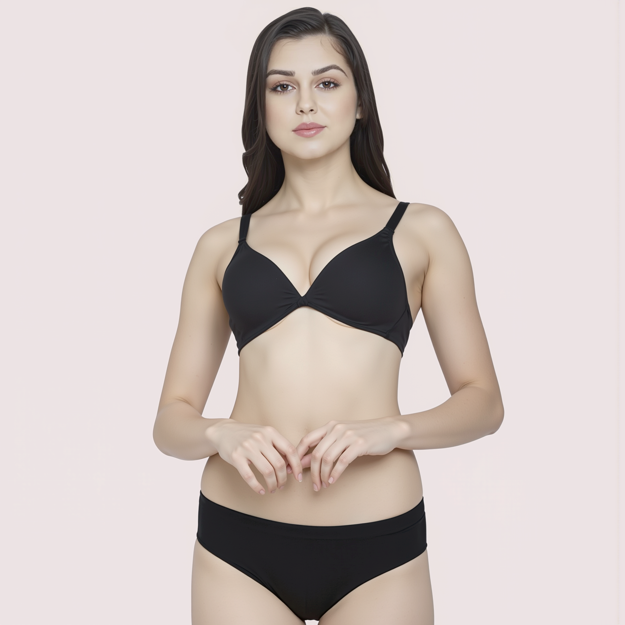 Woman wearing a black bra and panties set on a light pink background