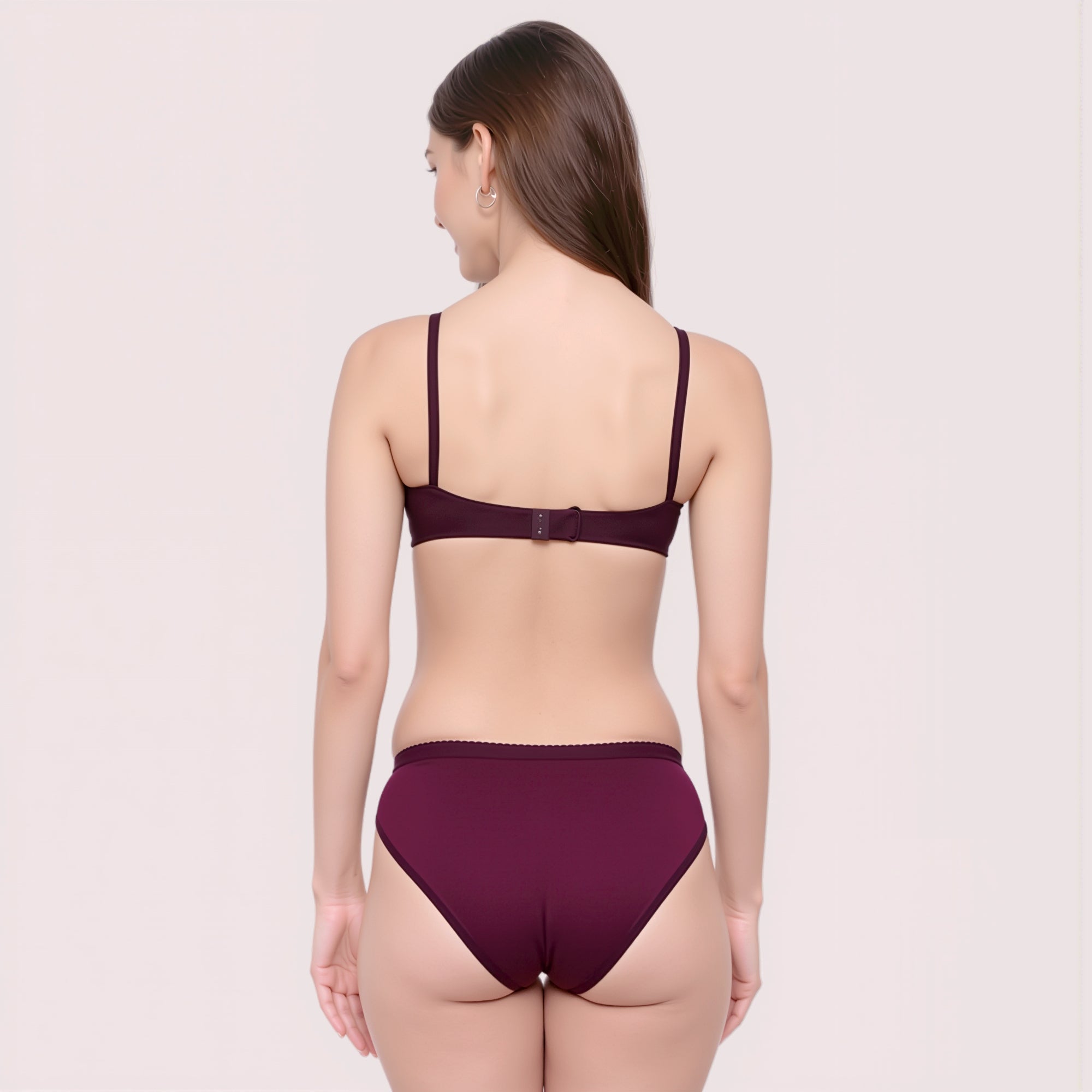 Woman wearing a dark purple bra and panties set on a light beige background