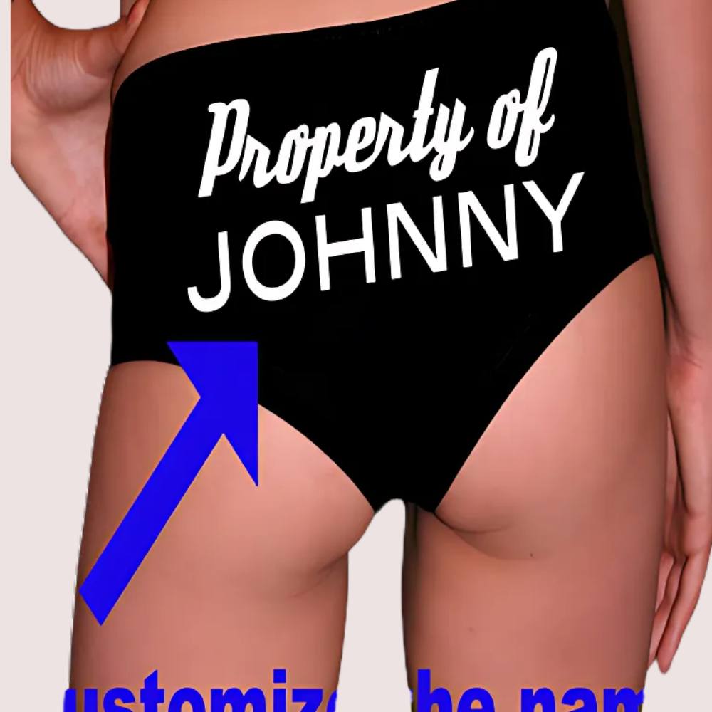 Black underwear with 'Property of JOHNNY' text and a blue arrow pointing to it on a plain background.