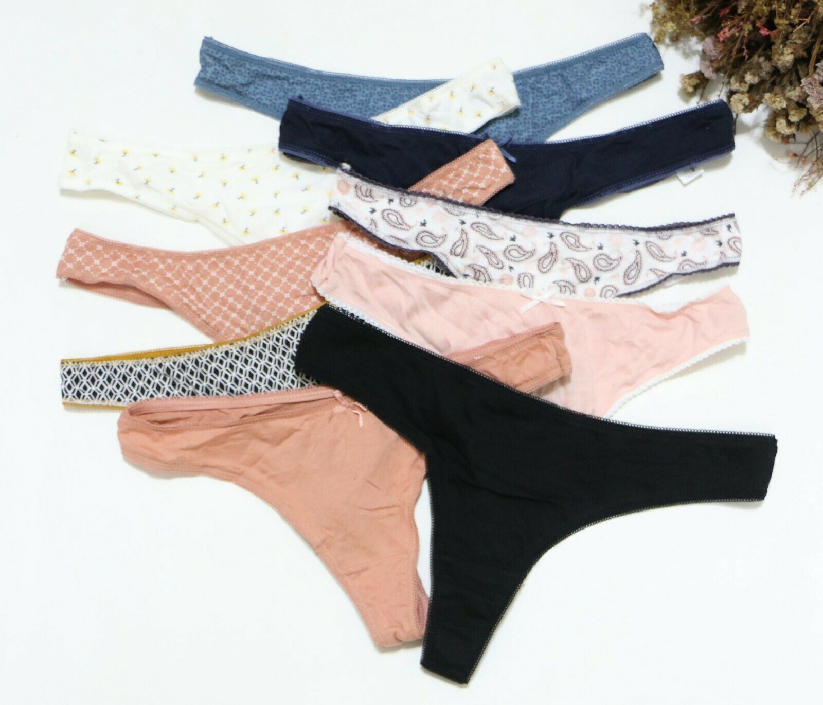 Various pairs of women's underwear in different colors and patterns on a white background.