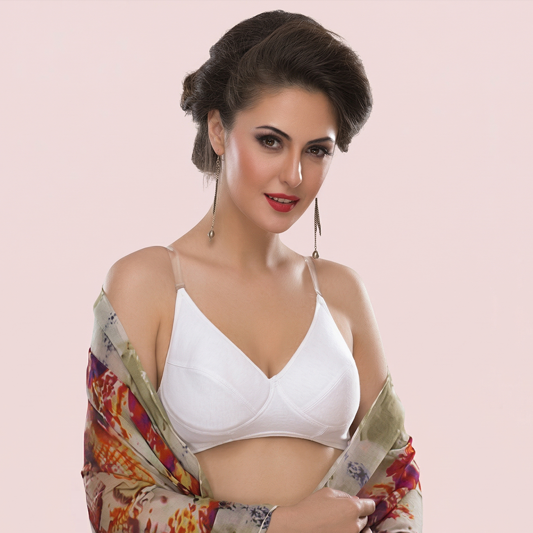 Woman wearing a white bra and colorful shawl on a light pink background