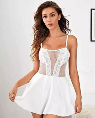 Woman wearing a white lace dress against a plain background