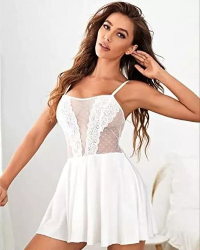 Woman wearing a white lace dress against a plain background