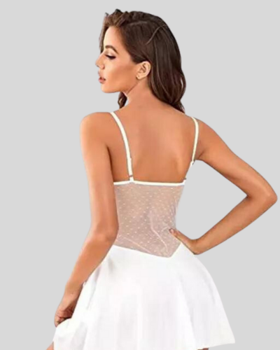Woman wearing a sheer top with a white skirt on a gray background