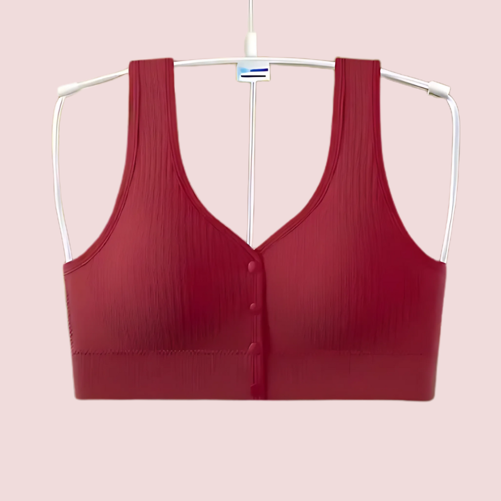 Red bra on a white hanger against a pink background