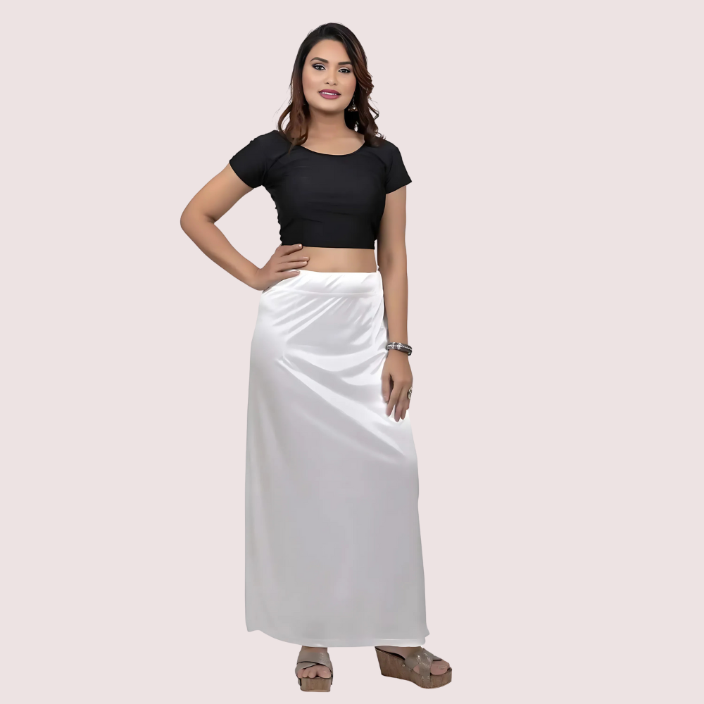 Woman wearing a black top and white skirt on a light pink background